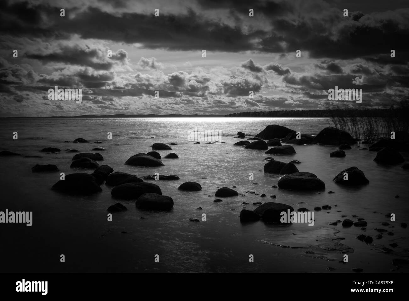 Dramatic black and white landscape of a lake with stones. Stock Photo