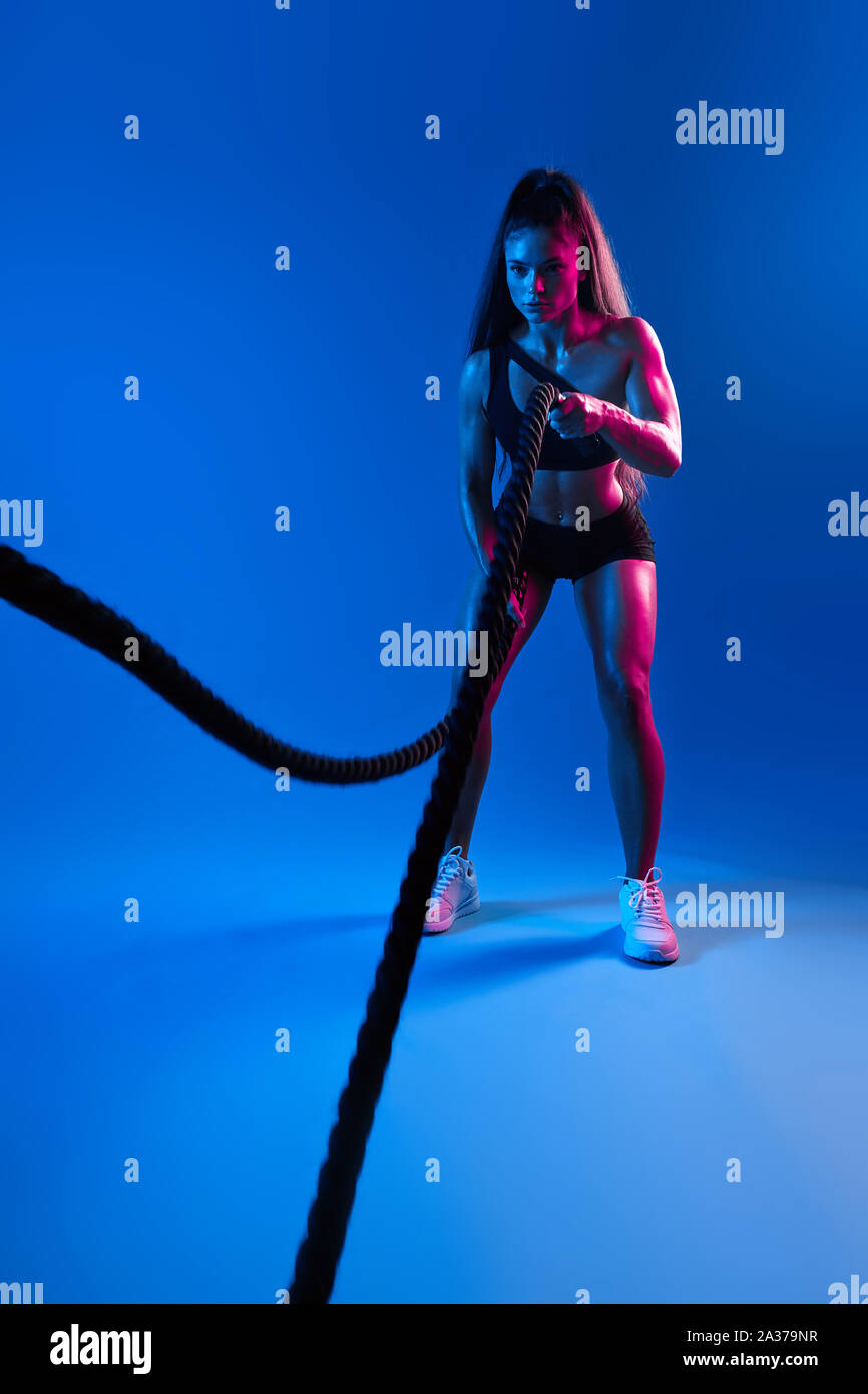 aweasome beautiful sweaty woman working out with battle ropes, full ...