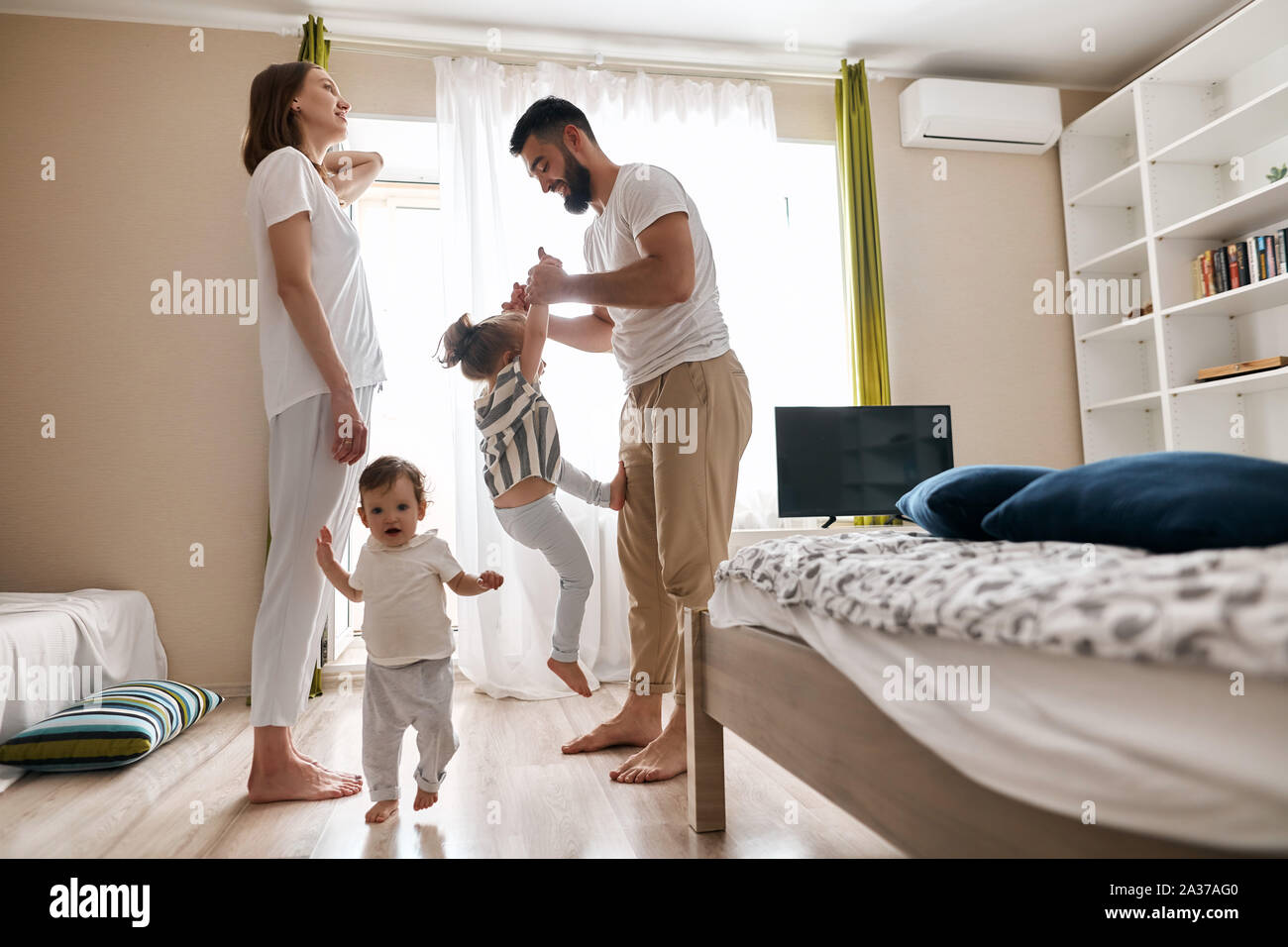 Happy Cheerful Family Having Fun In The Bedroom Side View