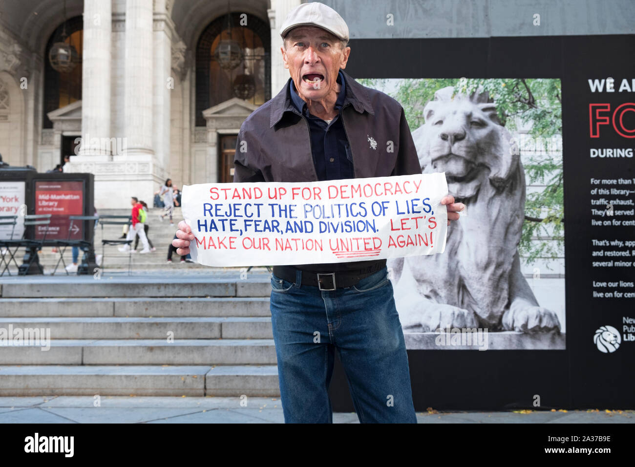 An anti Trump septuagenarian war veteran lectured tourists and passersby bout democracy. In front of the Main Library on Fifth Ave in Midtown, NYC. Stock Photo