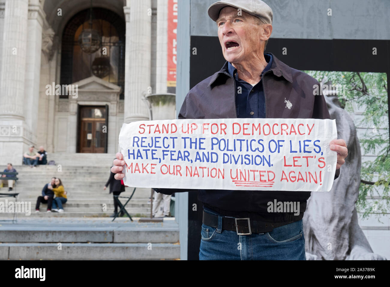 An anti Trump septuagenarian war veteran lectured tourists and passersby bout democracy. In front of the Main Library on Fifth Ave in Midtown, NYC. Stock Photo