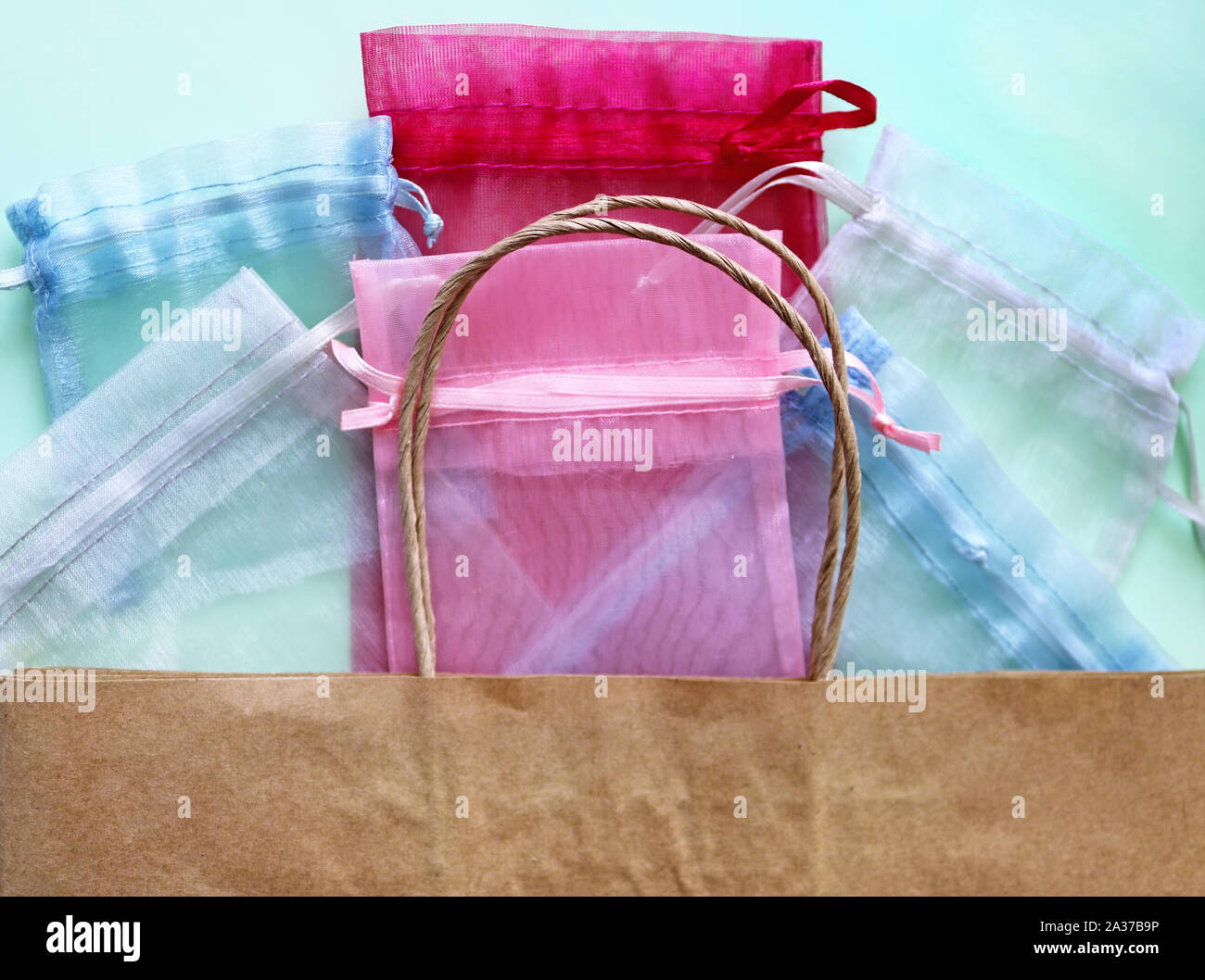 Organza bags and recycled eco bag on blue background. Organza bags can be used for storage different things for a long time. Waste zero reuse concept. Stock Photo