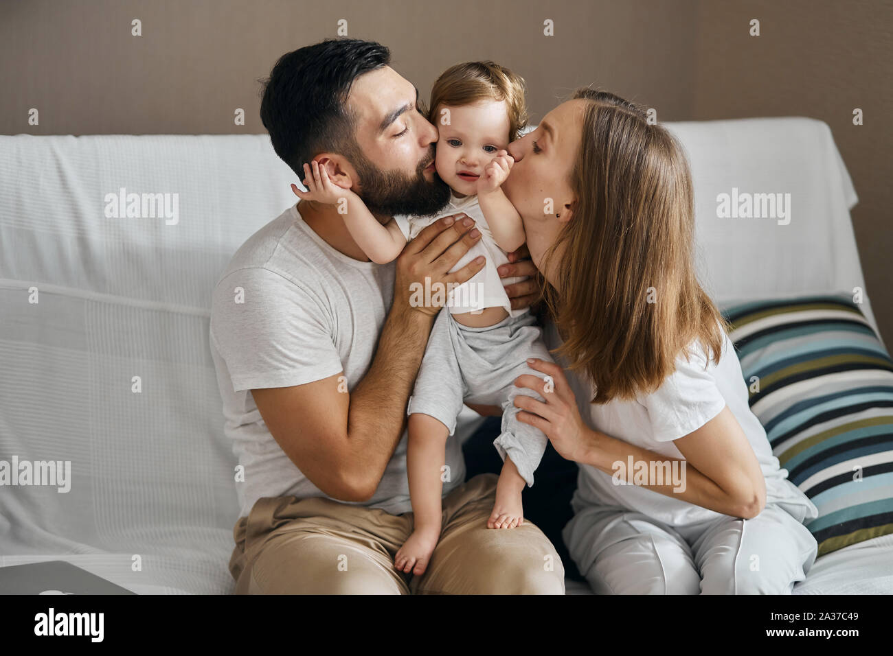 young parents kissing their child, close up photo. love, friendship