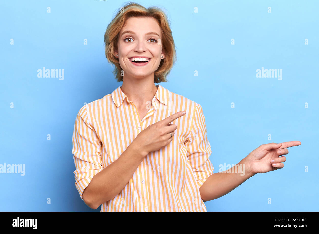 positive woman pointing with two fingers aside, close up portrait, look here, copy soace, lace for advert Stock Photo