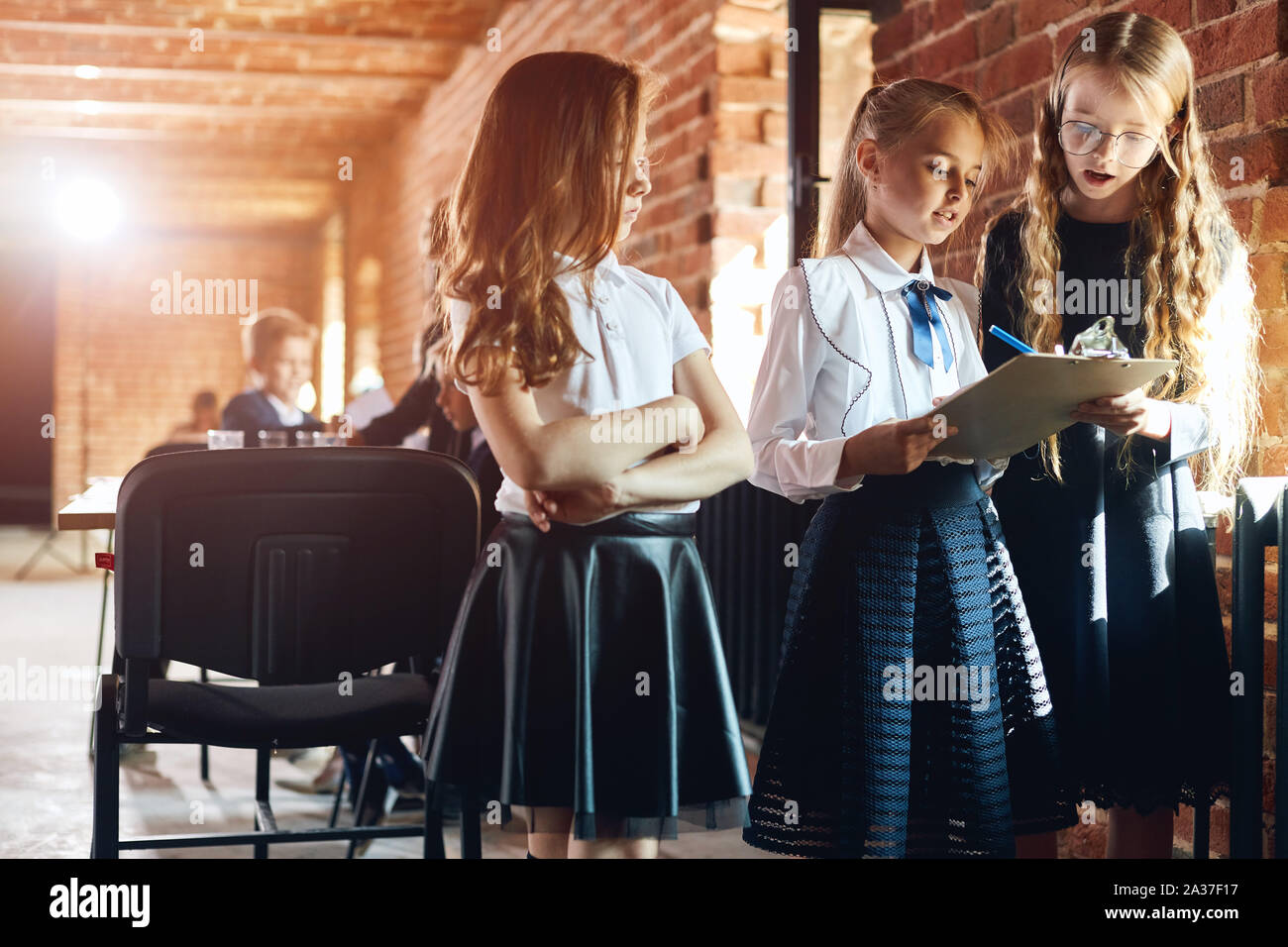 three girl in stylish formal clothes making notes, holding a notebook, analyzing documents. close up photo Stock Photo