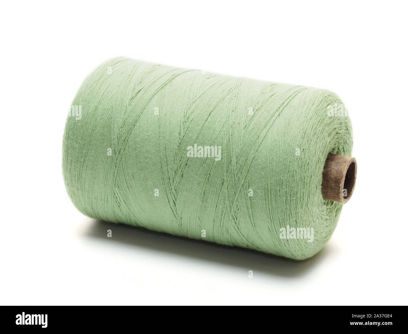 Green spool of thread in a horizontal position on a white background Stock Photo