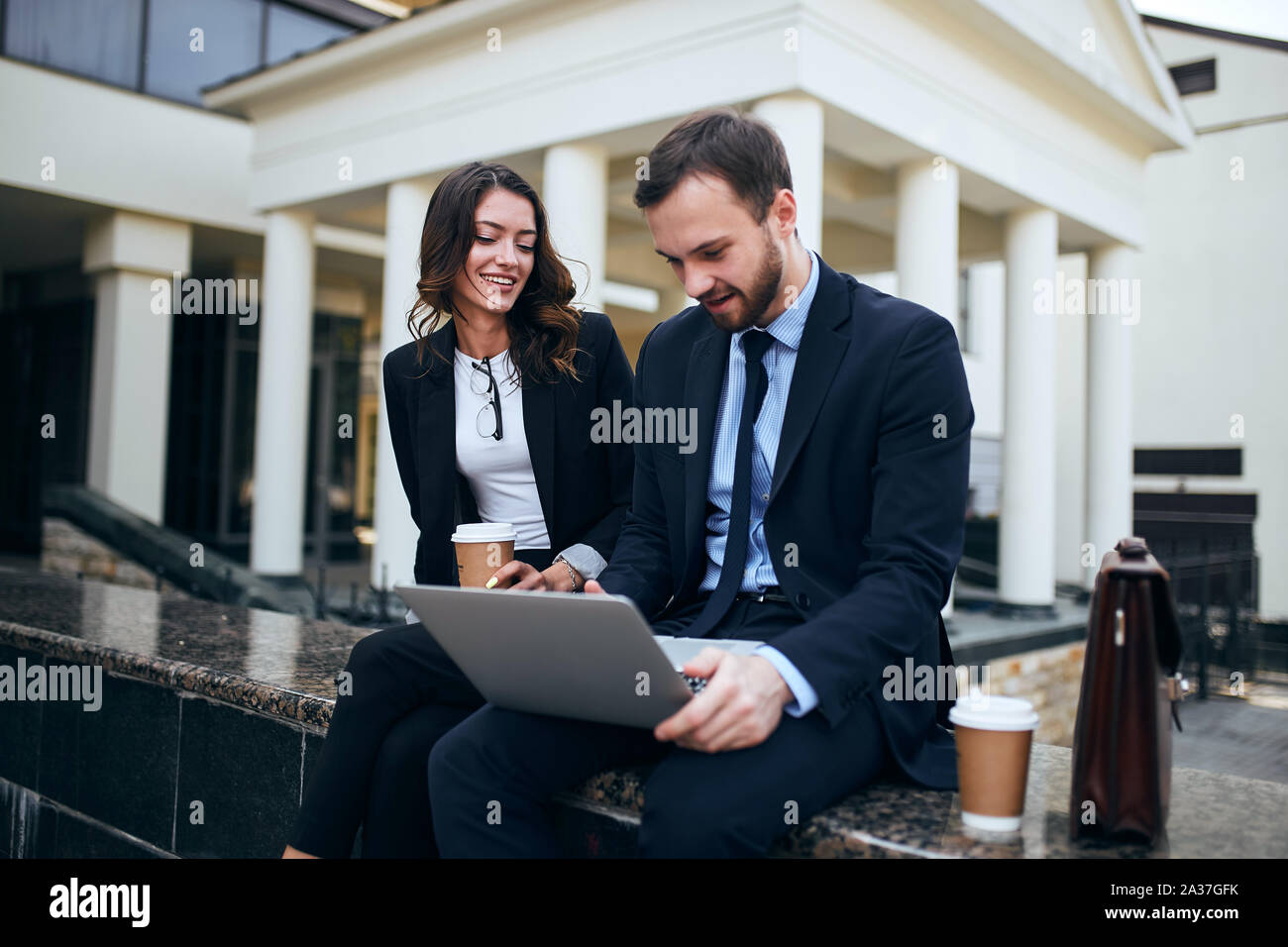 positive young co-workers drinking coffee, checking document,preparing a project. close up photo Stock Photo