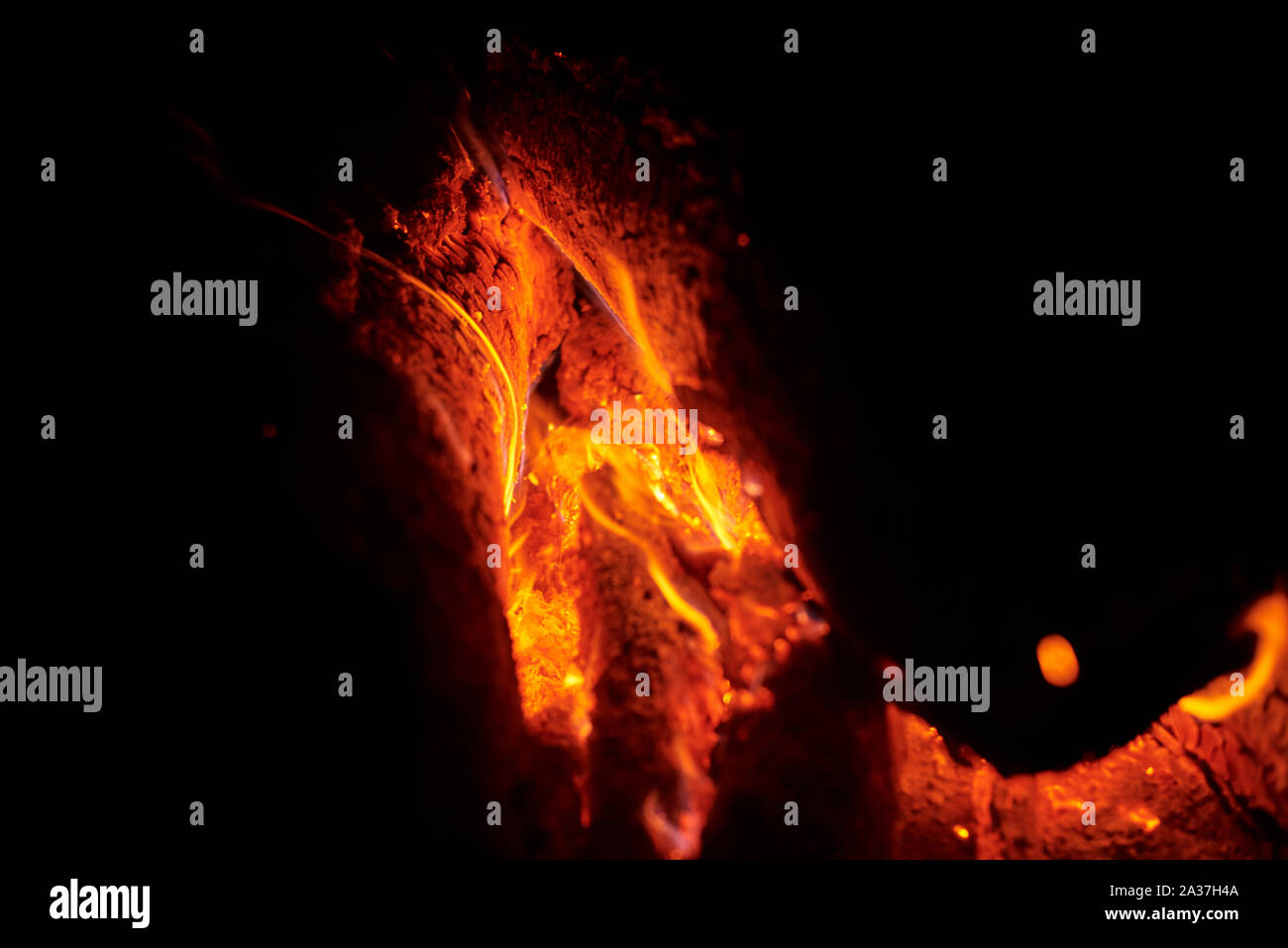 Close up of bonfire with sparks at night. Heat from burning logs and ...