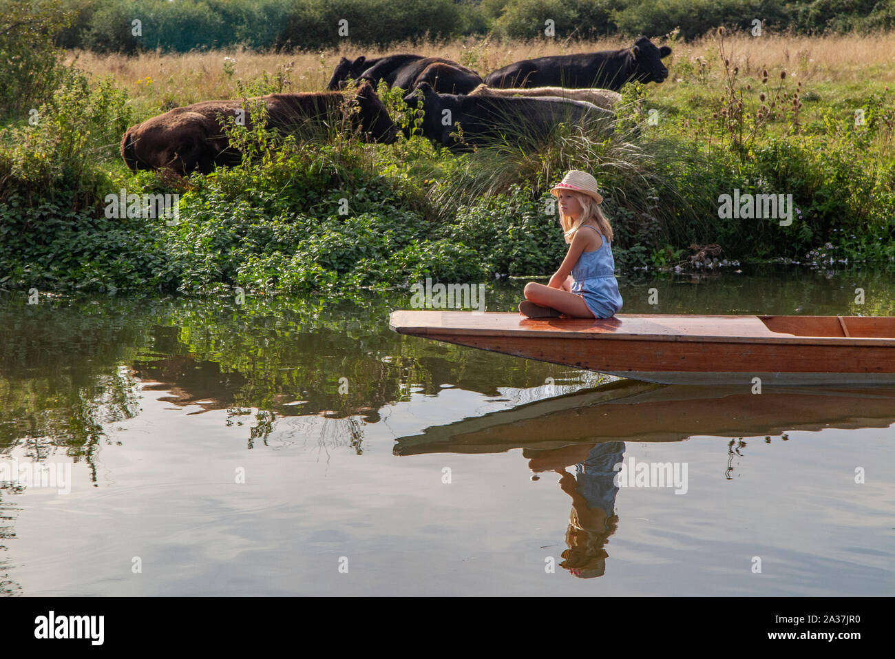 A pretty girl sits on the bow of a punt on the River Cherwell in Oxford, Oxfordshire Stock Photo