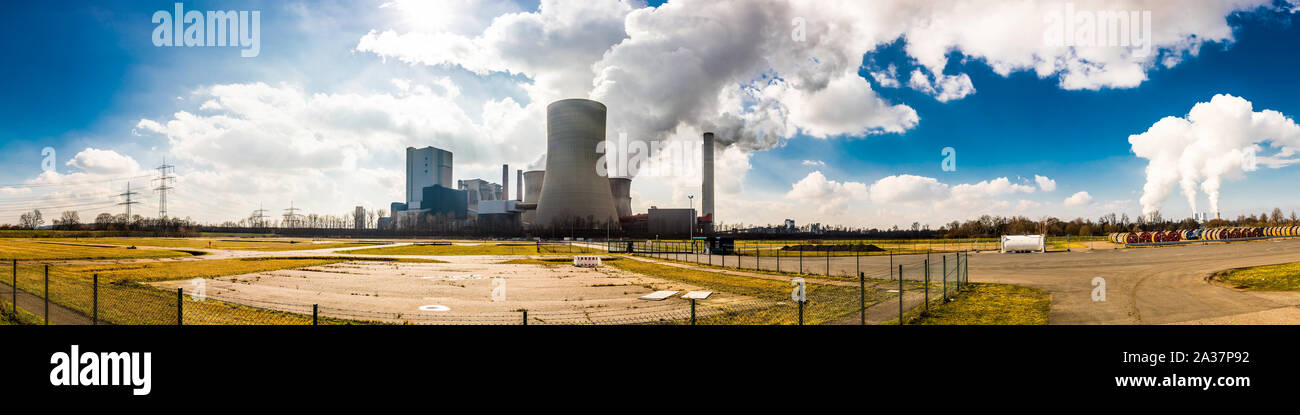 Panorama of an area with a big power plant with smoking cooling towers Stock Photo
