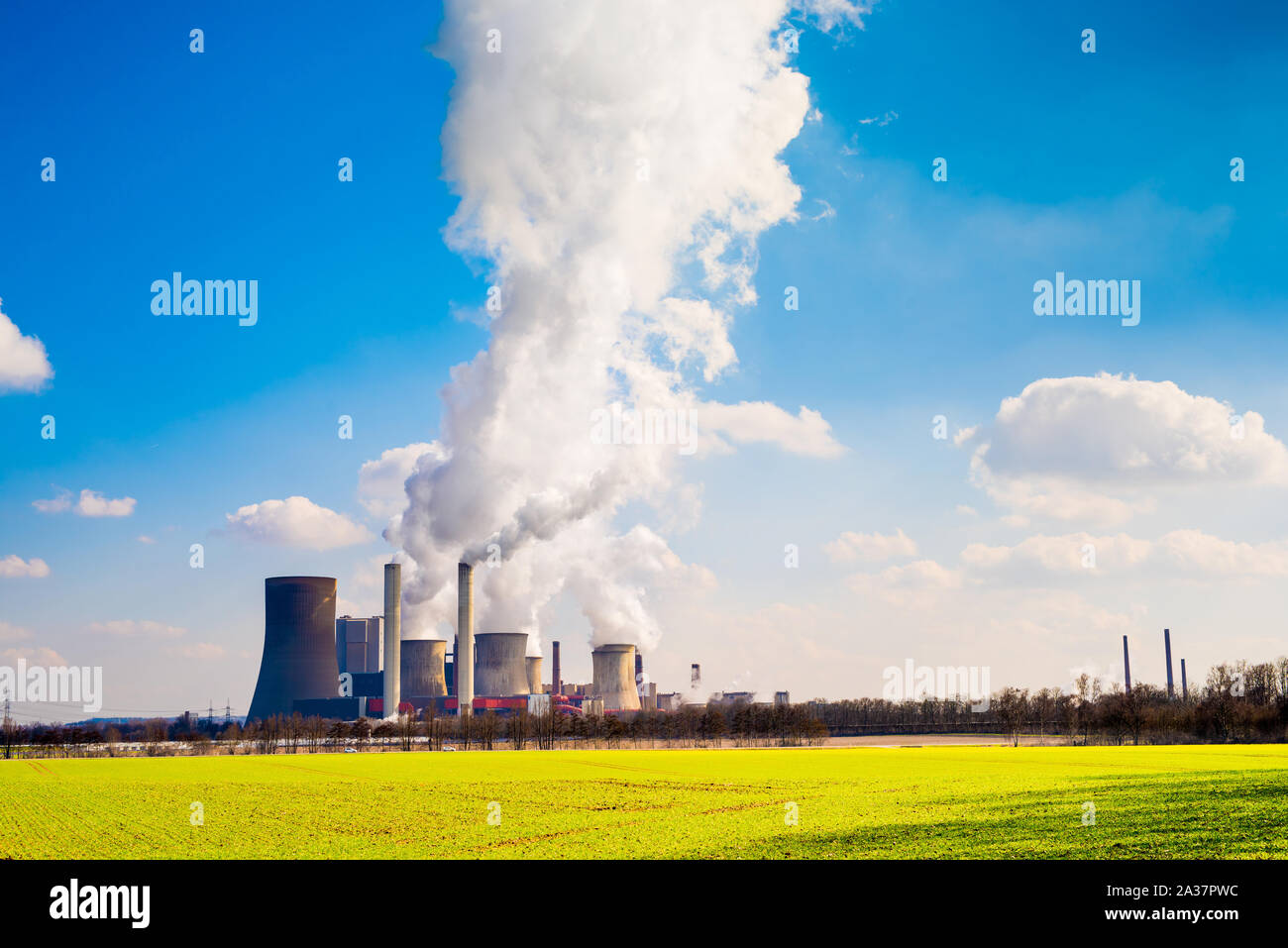 Power plant with smoking cooling towers Stock Photo