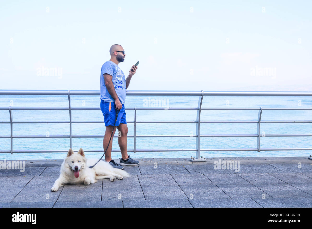 October 6, 2019, Beirut, Lebanon: A man with his dog at the seafront during a hot and humid day in Beirut. (Credit Image: © Amer Ghazzal/SOPA Images via ZUMA Wire) Stock Photo