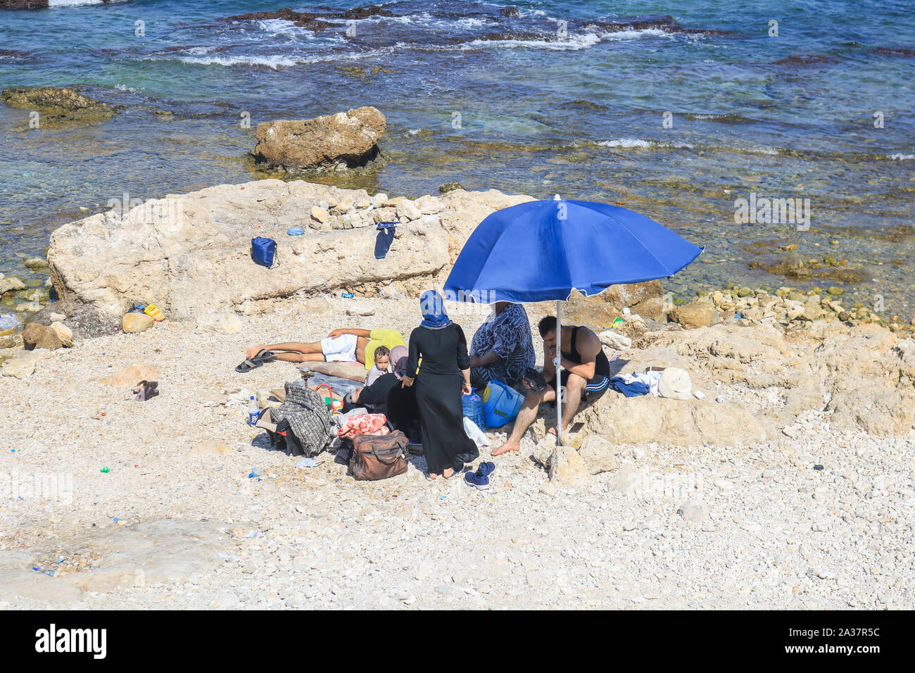 October 6, 2019, Beirut, Lebanon: A family shelters at the seafront during the hot and humid day in Beirut. (Credit Image: © Amer Ghazzal/SOPA Images via ZUMA Wire) Stock Photo