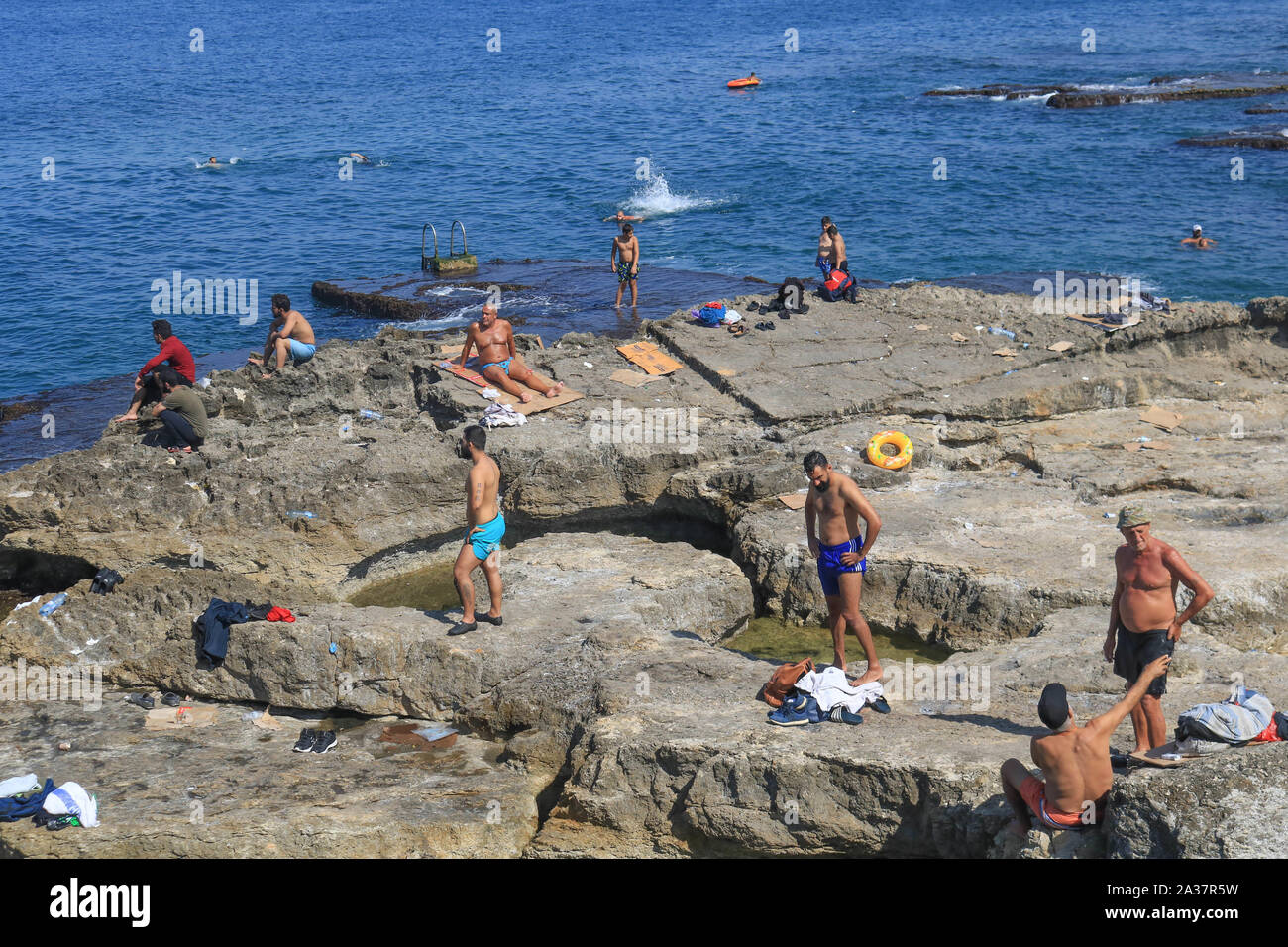 October 6, 2019, Beirut, Lebanon: People at the rocky seafront of the sea during the hot and humid day in Beirut. (Credit Image: © Amer Ghazzal/SOPA Images via ZUMA Wire) Stock Photo