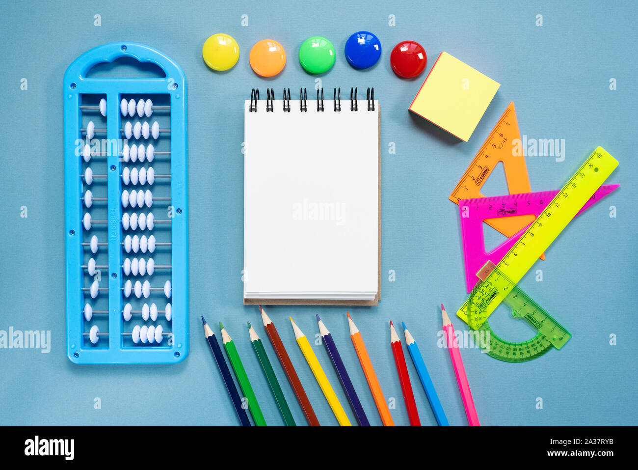 Blank page notebook and school accessories on blue flat lay background ...