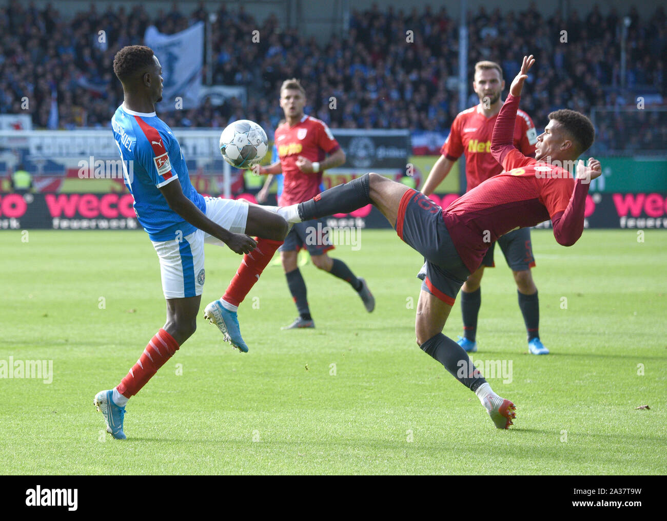 Kiel, Germany. 06th Oct, 2019. Soccer: 2nd Bundesliga, Matchday 9: Holstein Kiel - Jahn Regensburg in Holstein Stadium. Kiel's David Atanga (l) and Regensburg's Chima Okoroji fight for the ball. Credit: Daniel Bockwoldt/dpa - IMPORTANT NOTE: In accordance with the requirements of the DFL Deutsche Fußball Liga or the DFB Deutscher Fußball-Bund, it is prohibited to use or have used photographs taken in the stadium and/or the match in the form of sequence images and/or video-like photo sequences./dpa/Alamy Live News Stock Photo