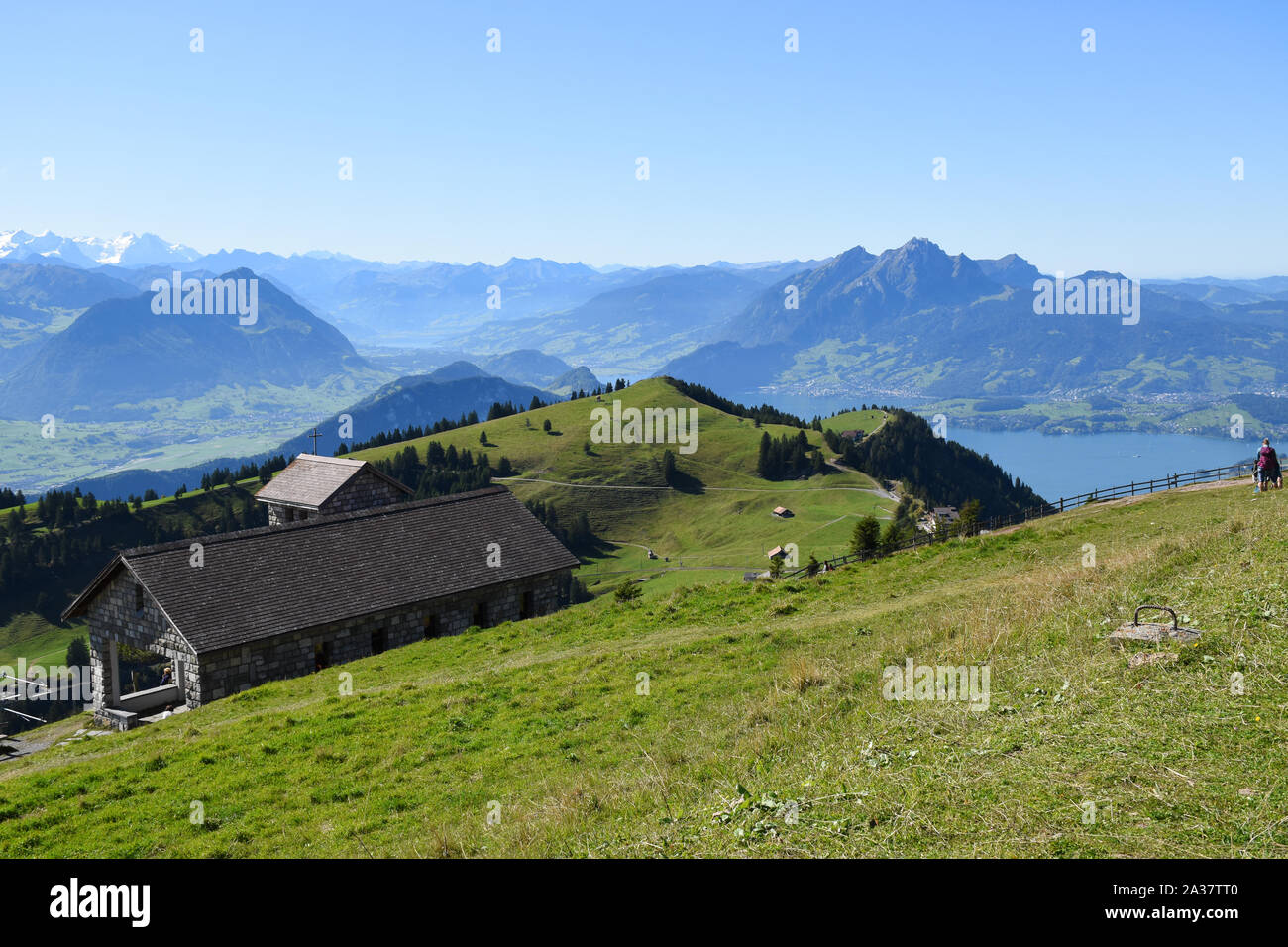 Panoramic landscape view of meadows, mountain ranges with snowy mountain peaks and Lake Lucerne in the background from the top of Rigi Kulm, Mount Rig Stock Photo