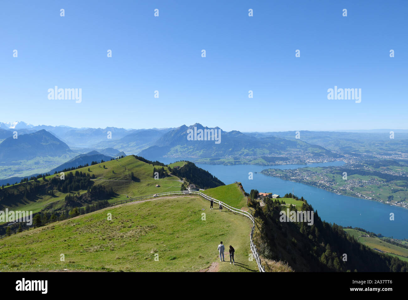 Panoramic landscape view of meadows, mountain ranges with snowy mountain peaks from the top of Rigi Kulm, Mount Rigi in Switzerland with Lake Lucerne Stock Photo