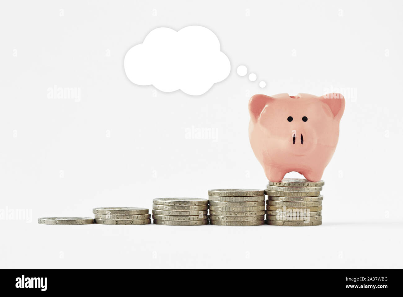 Piggy bank with blank comcic bubble on raising piles of coins - Concept of saving money Stock Photo