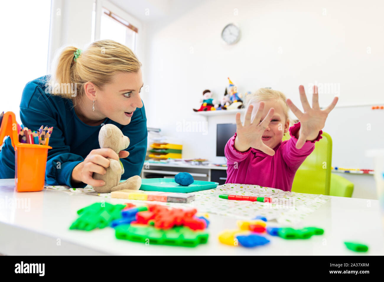 Toddler girl in child occupational therapy session doing sensory