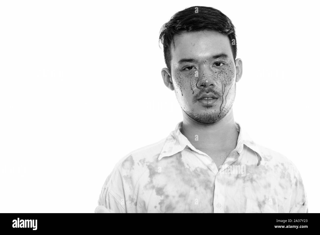 Studio shot of young crazy Asian man with blood on face Stock Photo