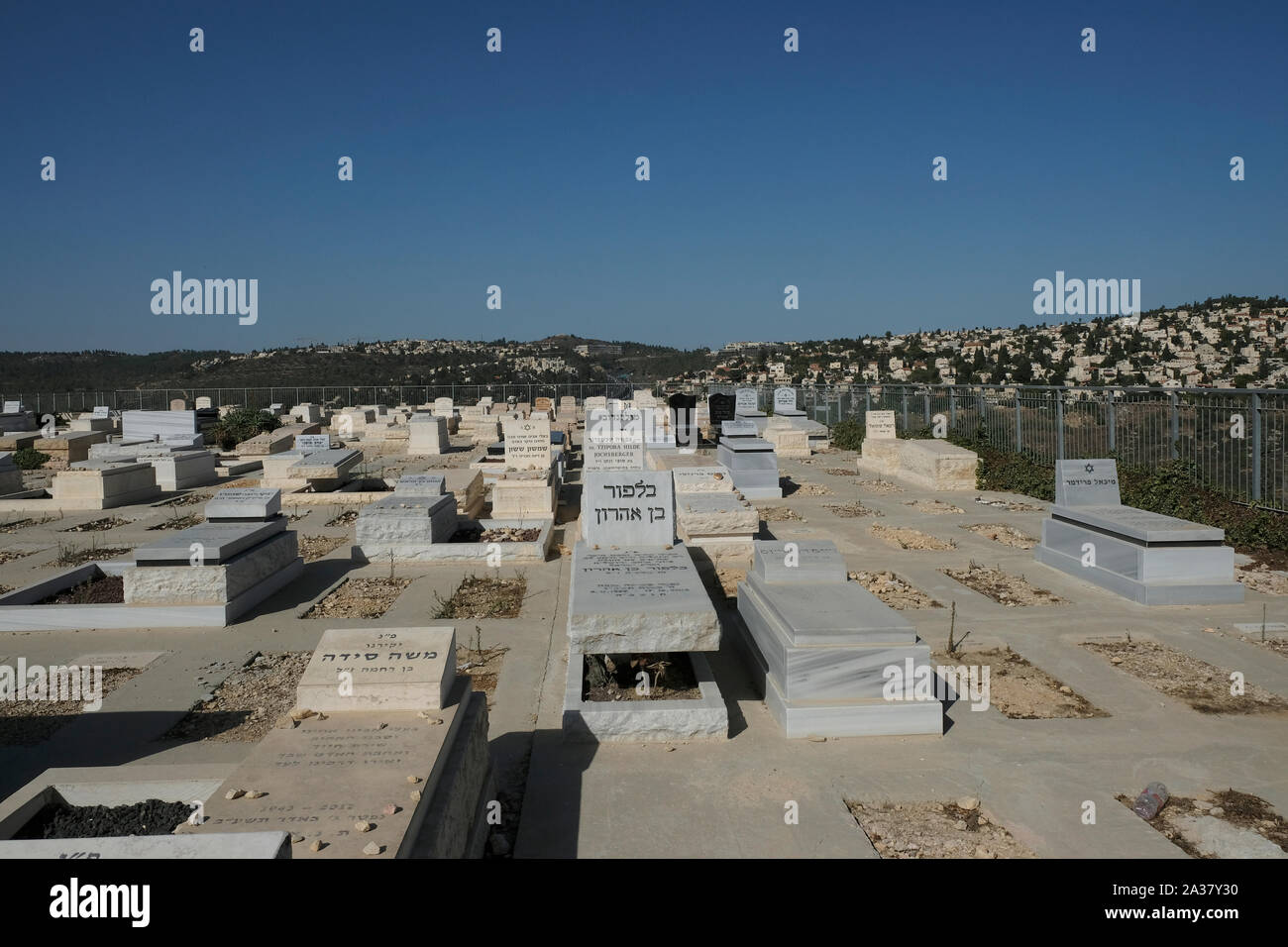 View of Mevaseret Zion and Motza local councils of Jerusalem across tombstones at Har HaMenuchot also known as Givat Shaul Cemetery the largest cemetery in West Jerusalem, Israel. Stock Photo