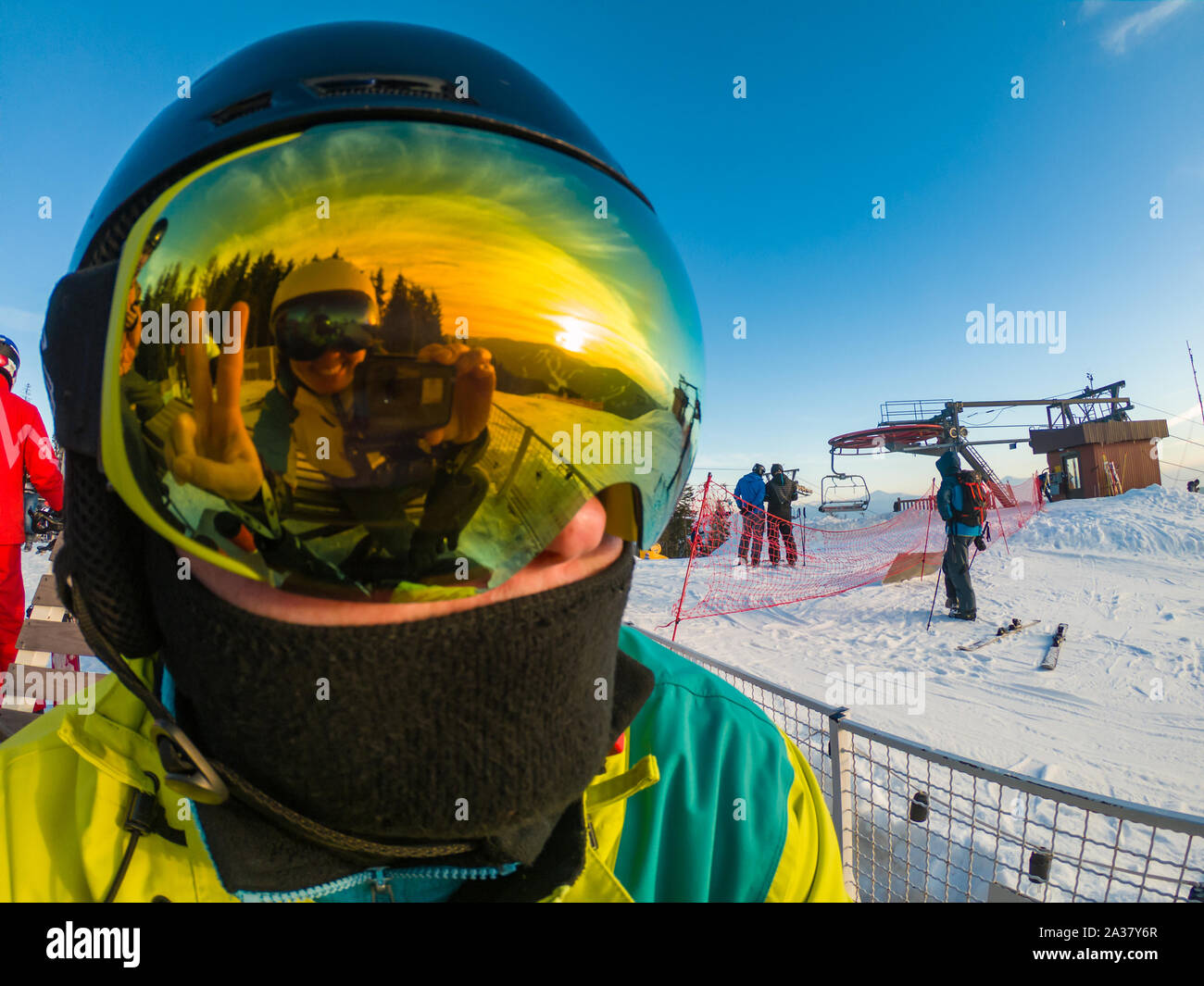 man in ski mask close up. reflection. snowed mountains on sunset Stock Photo