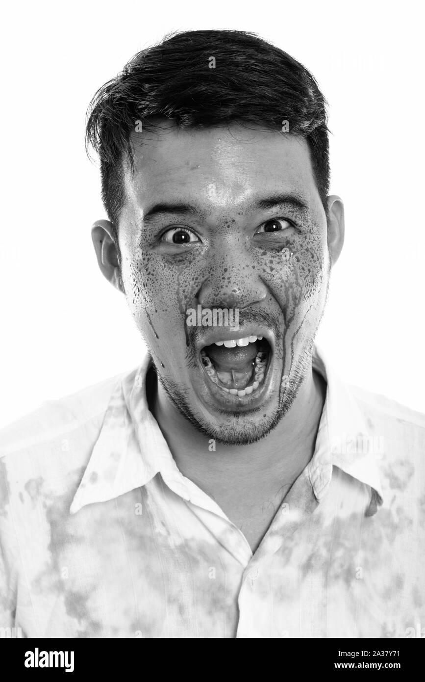 Face of young crazy Asian man screaming with blood on face Stock Photo