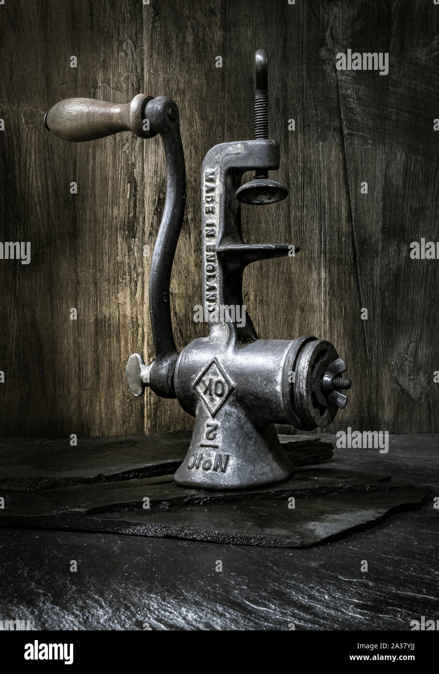 Vintage meat grinder still life. Old fashioned tools from the kitchen of yesteryear. Stock Photo