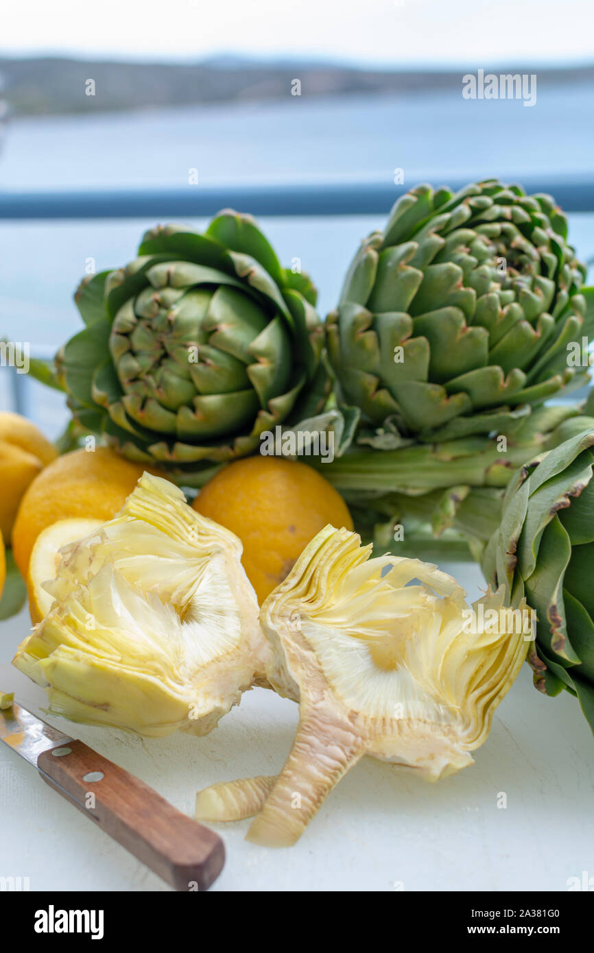 Preparation of heads of fresh raw green artichokes plants from