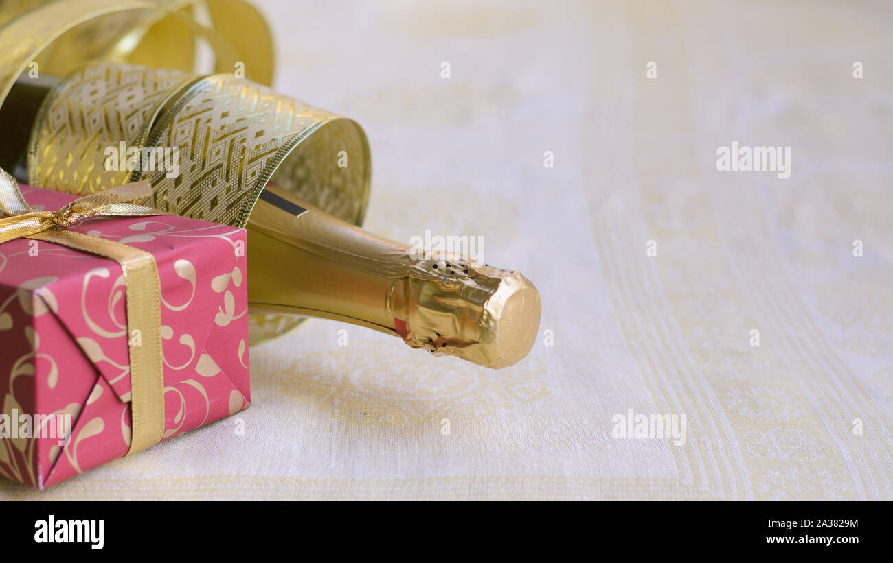 The bottle of champagne with gold glossy ribbon and red gift. Happy New ...
