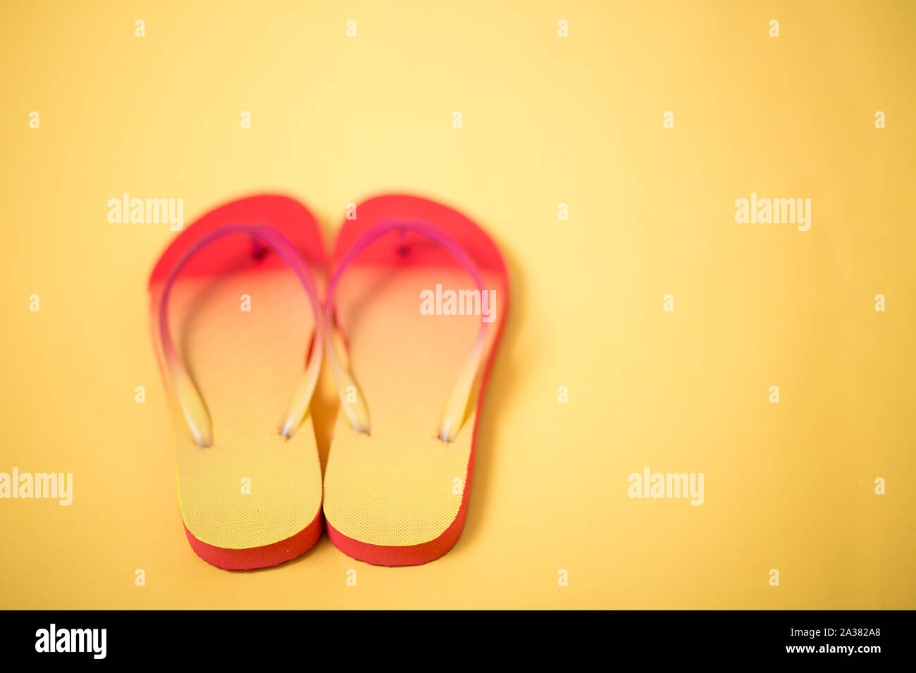 Coral pink sandals on yellow background with copy space. Flat lay ...