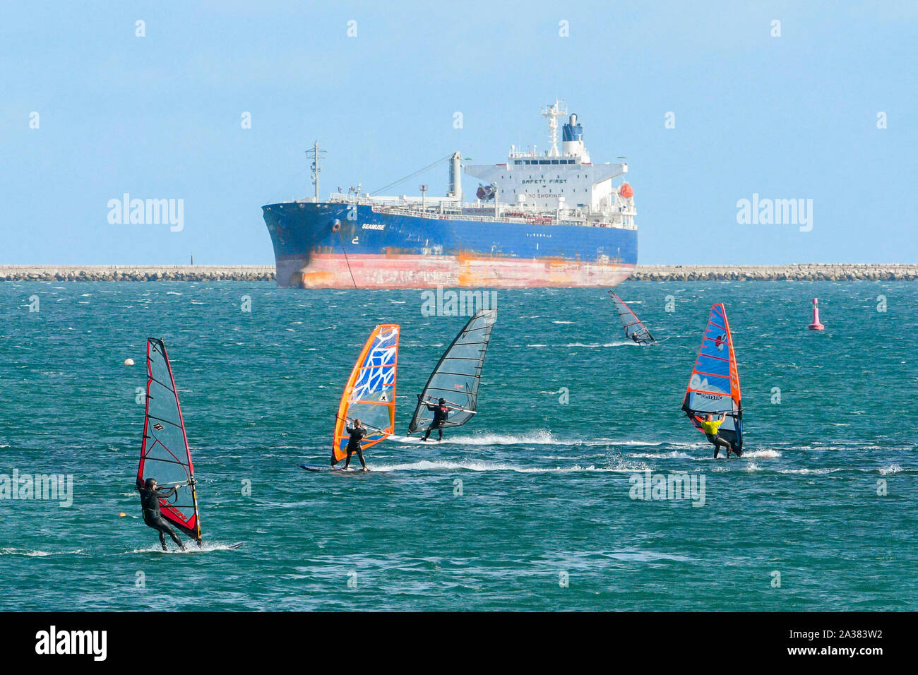 Wyke Regis, Dorset, UK.  6th October 2019. UK Weather.  Blustery winds and sunshine make for perfect condtions for watersports as sailors, windsurfers and kitesurfers take to the water within Portland breakwater at Wyke Regis near Weymouth in Dorset as they speed across the sea.  Picture Credit: Graham Hunt/Alamy Live News Stock Photo