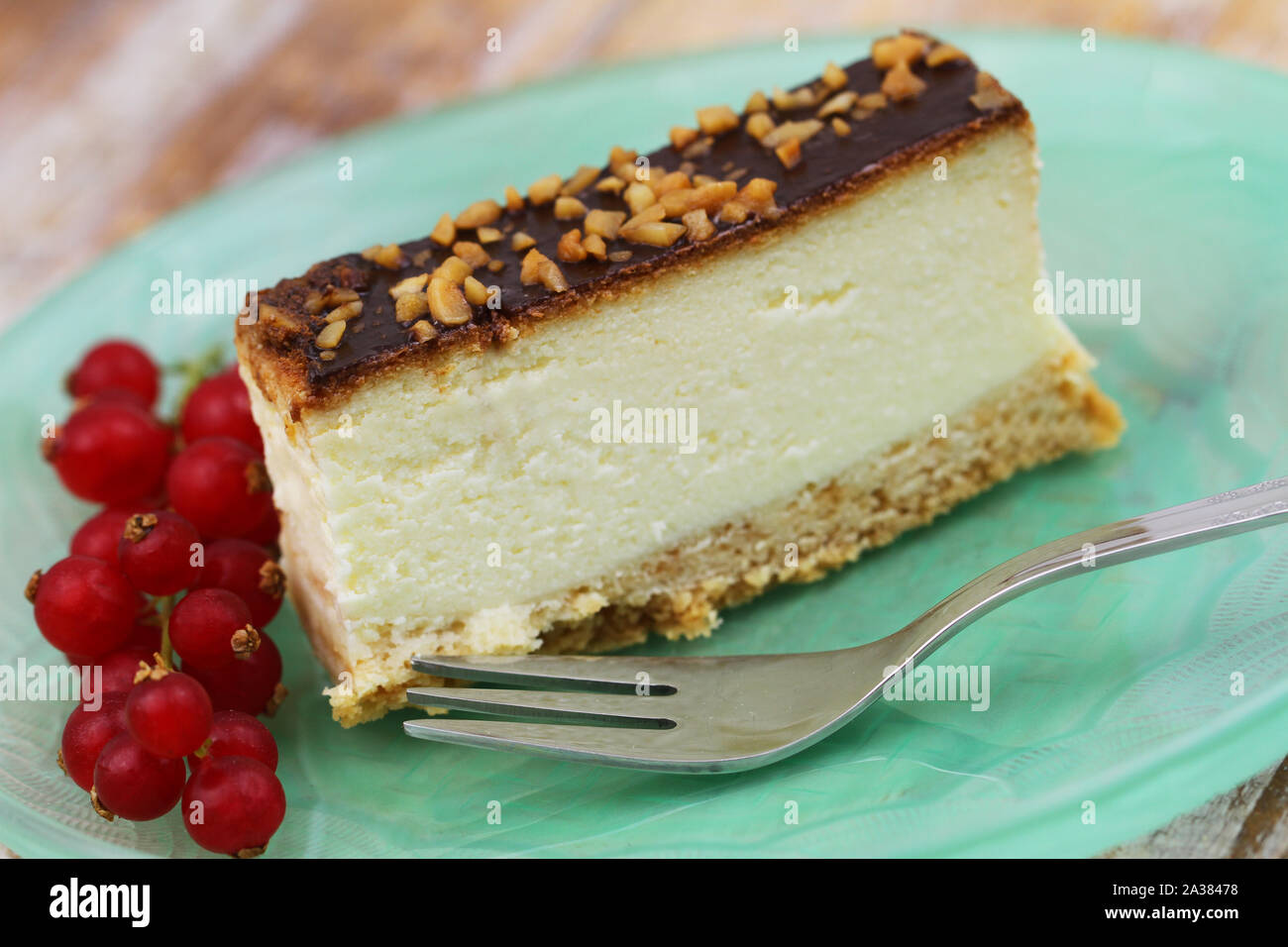 Slice of baked Polish cheesecake with chocolate topping and chopped nuts Stock Photo
