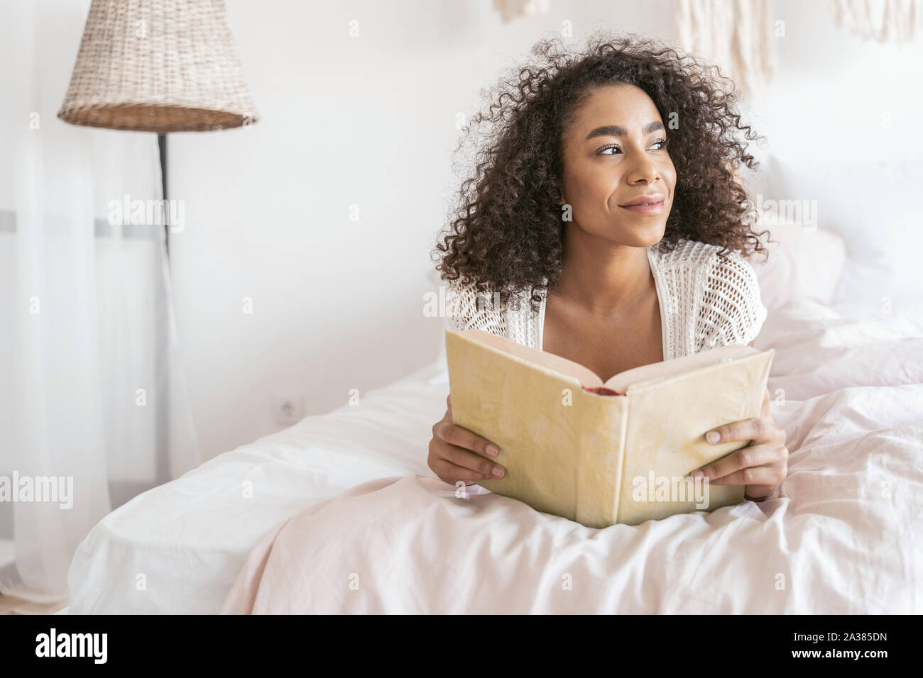 Relaxed female person holding book in both hands Stock Photo