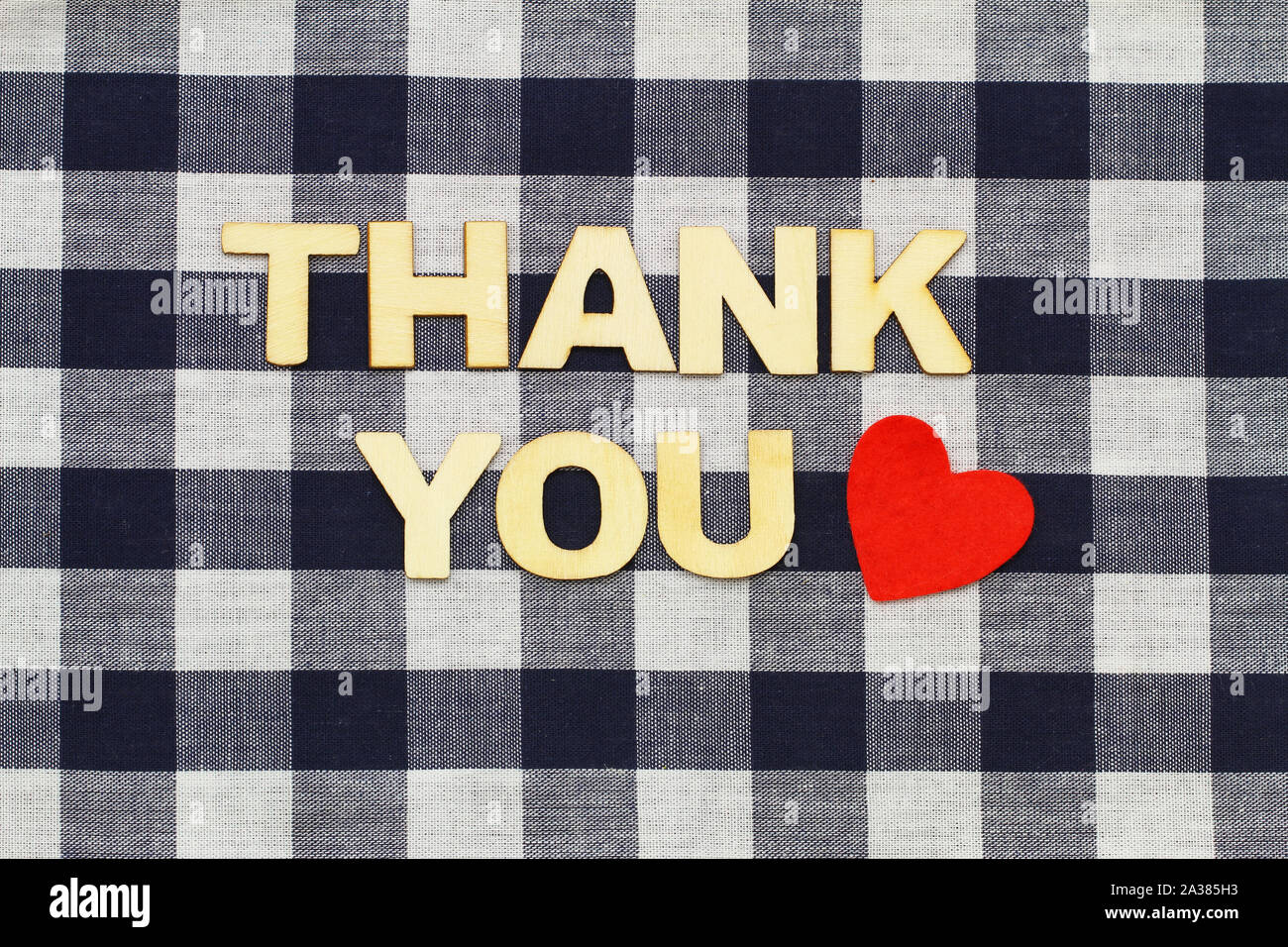 Thank you written on checkered surface and red heart Stock Photo