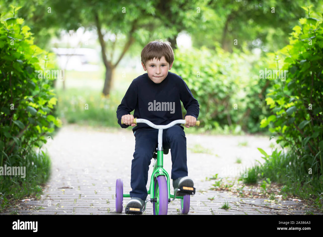 The boy on a tricycle.Child preschooler spin the pedals on a toy