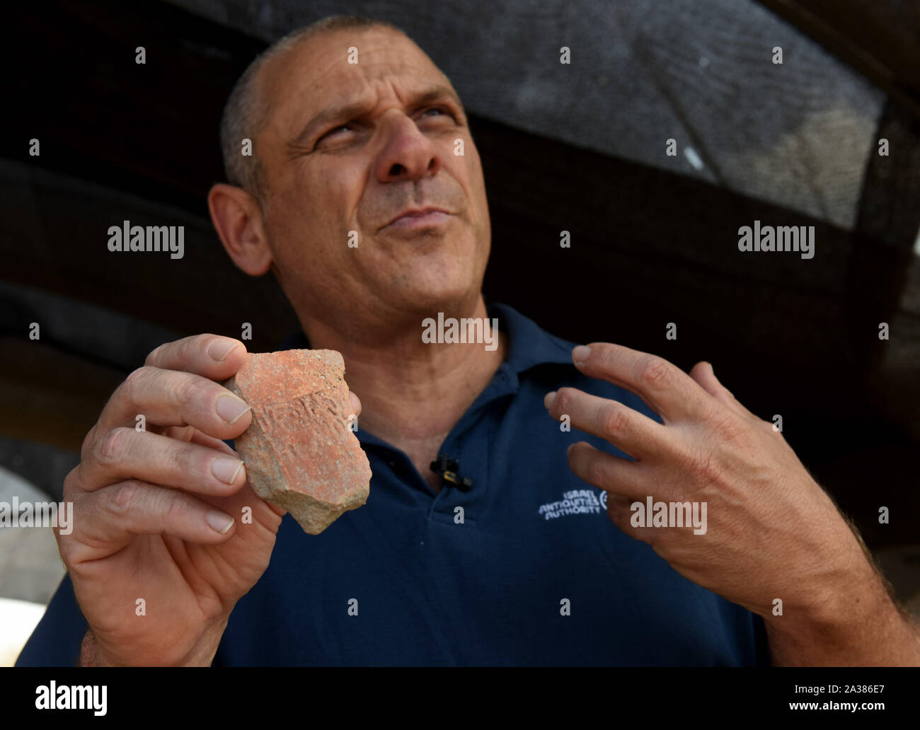 En Esur, Israel. 06th Oct, 2019. Dr. Yitzhak Paz, Excavation Director, holds a seal impression of a man hands lifted, discovered during excavations of a vast 5,000 cosmopolitan and planned city from the Early Bronze Age, one of the first and largest of the ancient Near East, excavated by the Israeli Antiquities Authority in En Esur, Israel, on Sunday, October 6, 2019. The En Esur archaeological site, located near Wadi Ara, was discovered prior to the construction of a highway interchange and revealed a massive city where 6,000 people lived. Photo by Debbie Hill/UPI Credit: UPI/Alamy Live News Stock Photo
