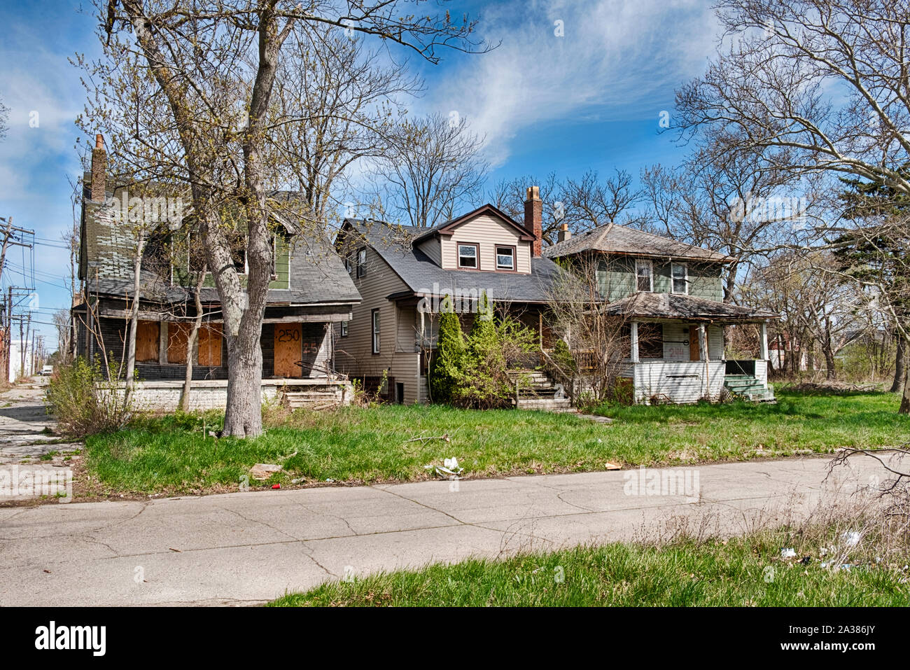 DETROIT, MICHIGAN - APRIL 27, 2019:  Three old houses have been abandoned and are gradually falling apart in a Detoit neighborhood. Stock Photo