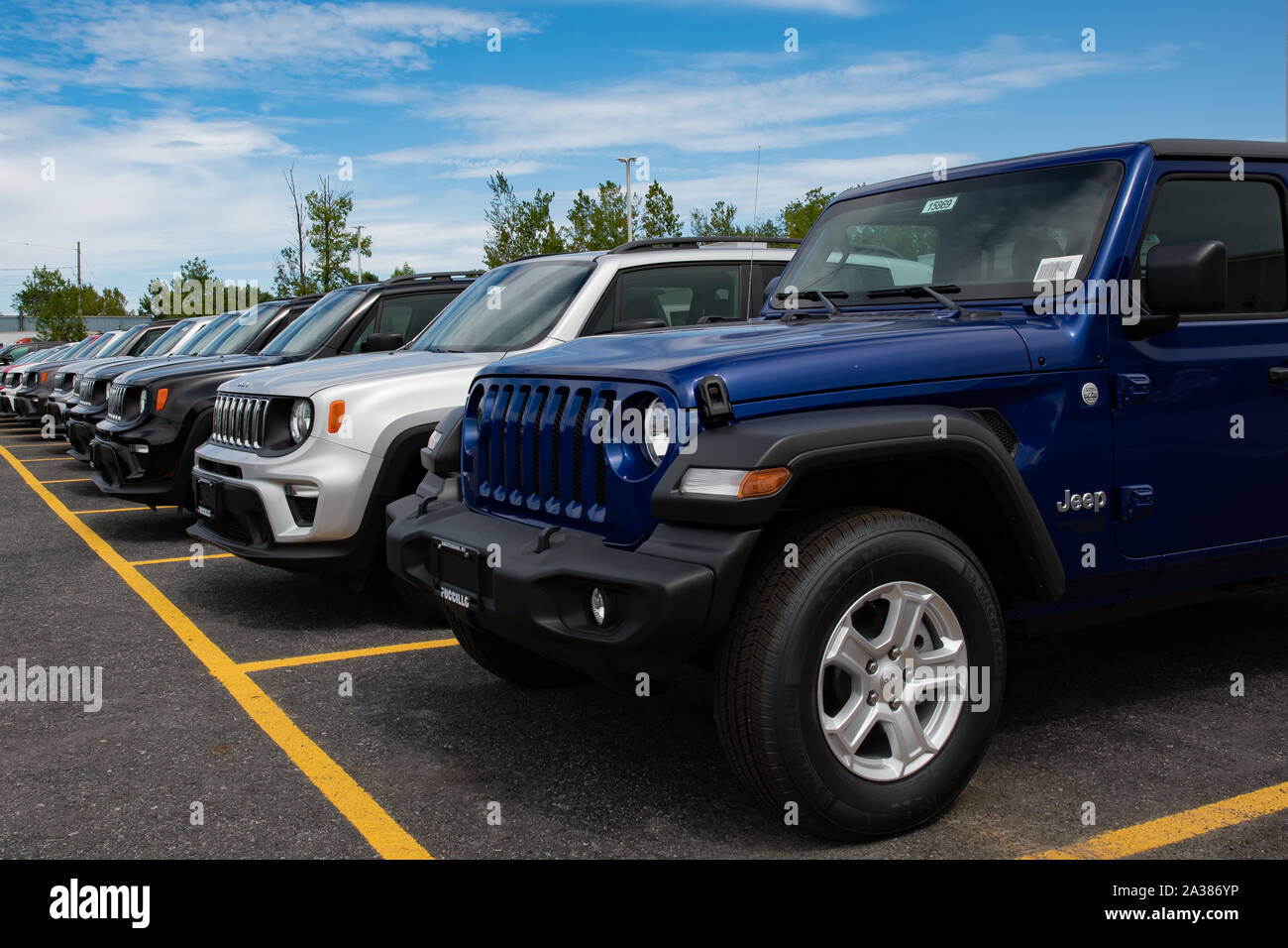 A line of new Jeep vehicles for sale on a dealers car lot in Amsterdam, NY USA including a Jeep Wrangler Unlimited and several Jeep Renegades. Stock Photo