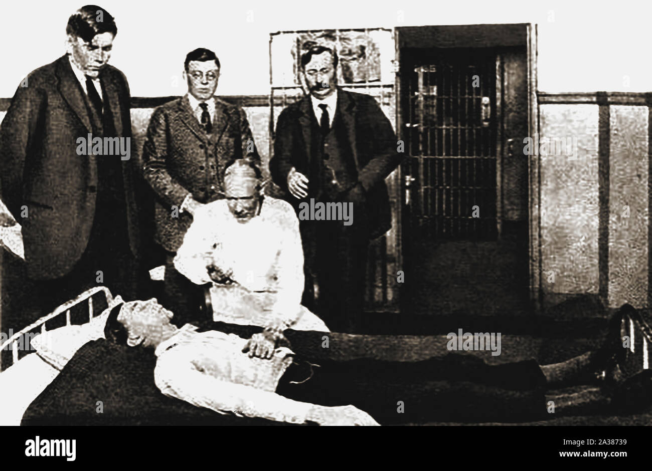 1930 periodical illustration - Law & Order in the USA -1930 newspaper picture of Dr R. E. House discoverer of  Scopolamine (Hyoscine) and  administering it as a truth drug in Dallas County Jail. With District Attorney  Cox, Senator Bowers and  Sheriff Harston stood behind him. Stock Photo