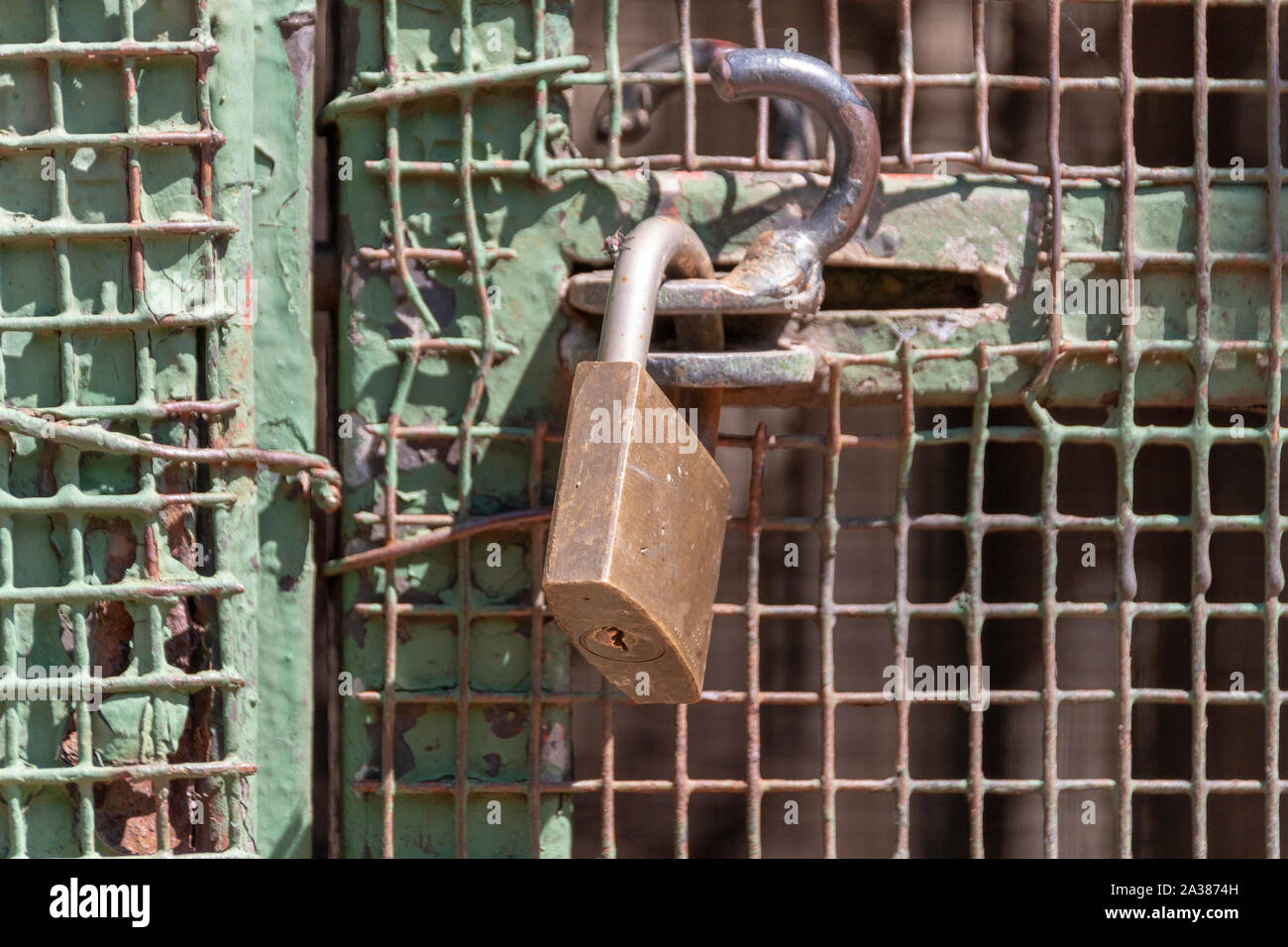 A close up view of a padlock keeping a metal gate closed Stock Photo