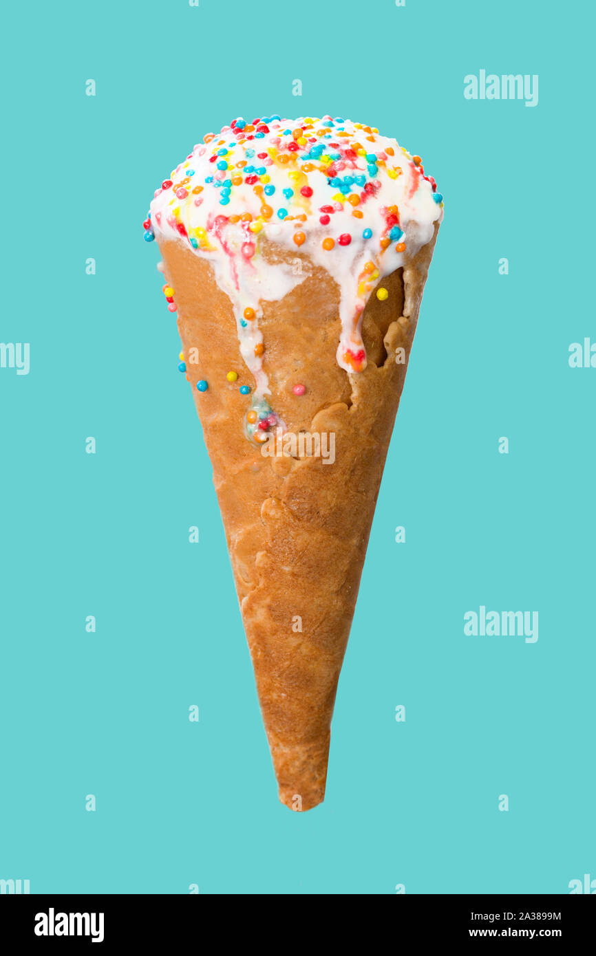 Ice cream cone close up. White ice cream scoop in a waffle cone on a blue background. Sweet dessert decorated with multicolored sprinkles Stock Photo