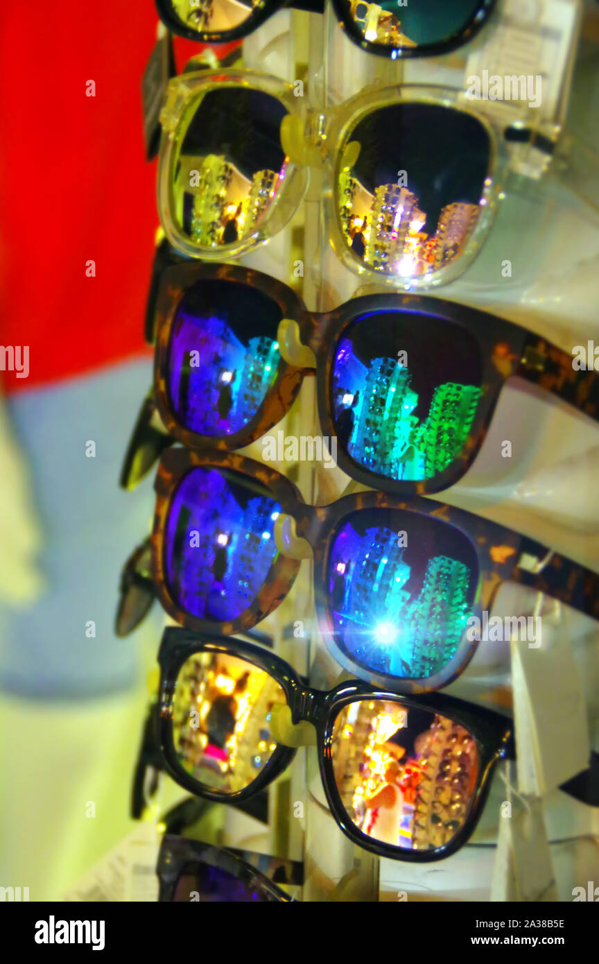Sunglasses on a hanger in the store. Stack of eyeglasses with reflection. Stock Photo