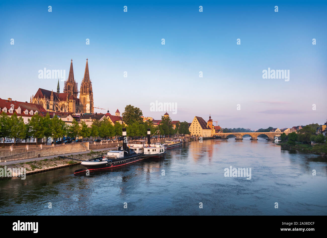 Regensburg cityscape as viewed from the Eiserne Brücke bridge with Donau-Schiffahrts-Museum on moored ships, St. Peter's Cathedral (Regensburger Dom) Stock Photo