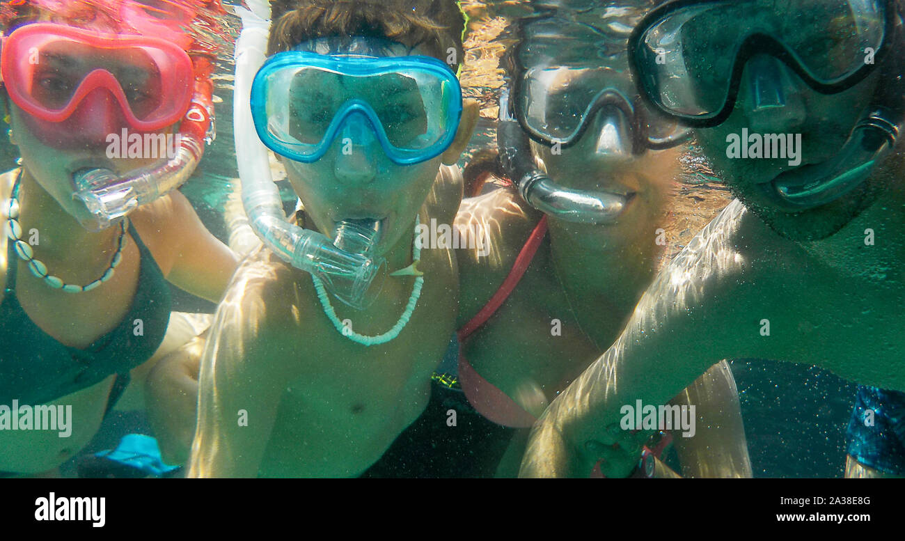 Underwater selfie shot of a Family of four wearing snorkels and masks