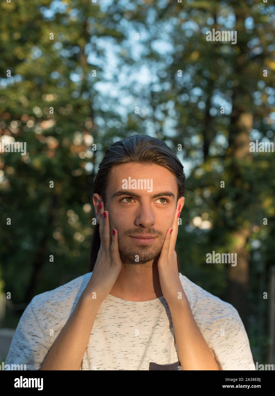 Woman's hands on a man's face Stock Photo