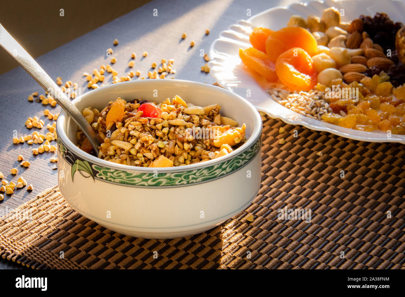Buckwheat granola and a plate of sunflower seeds, cashews, brazil nuts, almonds, apricots and raisins Stock Photo