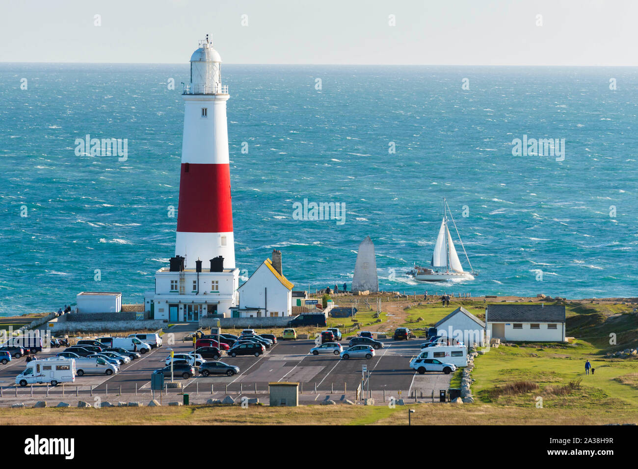 Portland Bill, Dorset, UK.  6th October 2019. UK Weather.  A yacht struggles to sail past Portland Bill lighthouse through the rough seas of Portland Race on a day of sunshine and strong gusty winds. The lighthouse at Portland Bill is currently being modernised by Trinity House with the old rotating optics being replaced by a new LED light.  Work started on 1st October is due to finish on 27th February 2020.  Picture Credit: Graham Hunt/Alamy Live News Stock Photo