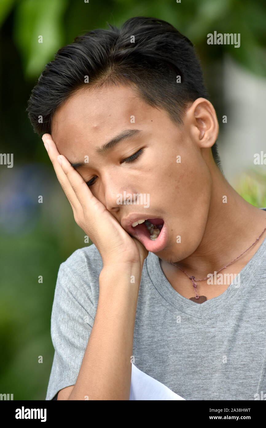A Yawning Youthful Filipino Teenager Boy Stock Photo